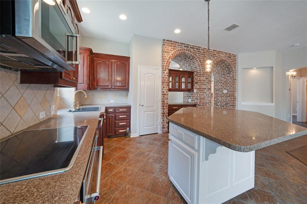 3418 Oakleigh Lane Frisco, TX 75033 - Photo 17 of 37 a kitchen with stainless steel appliances granite countertop a sink a refrigerator and a stove