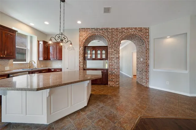 a large kitchen with stainless steel appliances granite countertop a large stove a sink and a microwave