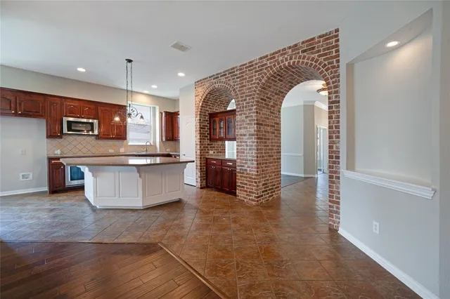 a view of a room with wooden floor a ceiling fan and windows