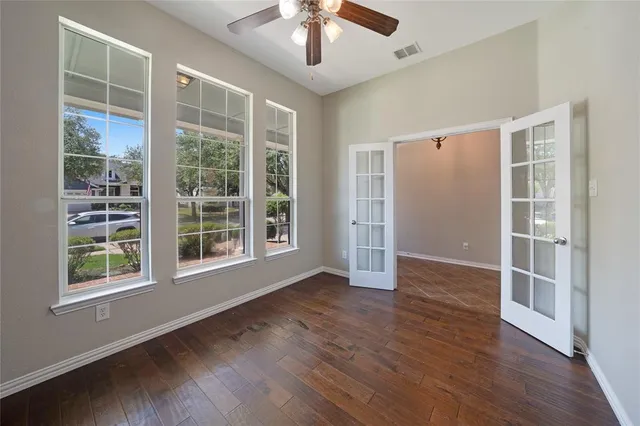 a view of an empty room with a kitchen and wooden floor