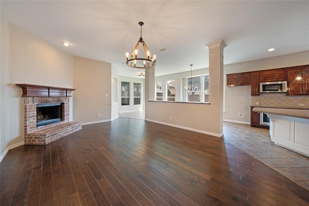 3418 Oakleigh Lane Frisco, TX 75033 - Photo 10 of 37 a view of a kitchen with a sink wooden cabinets and a fireplace