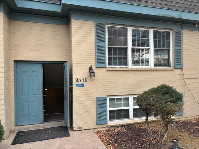 a front view of a house with a tree
