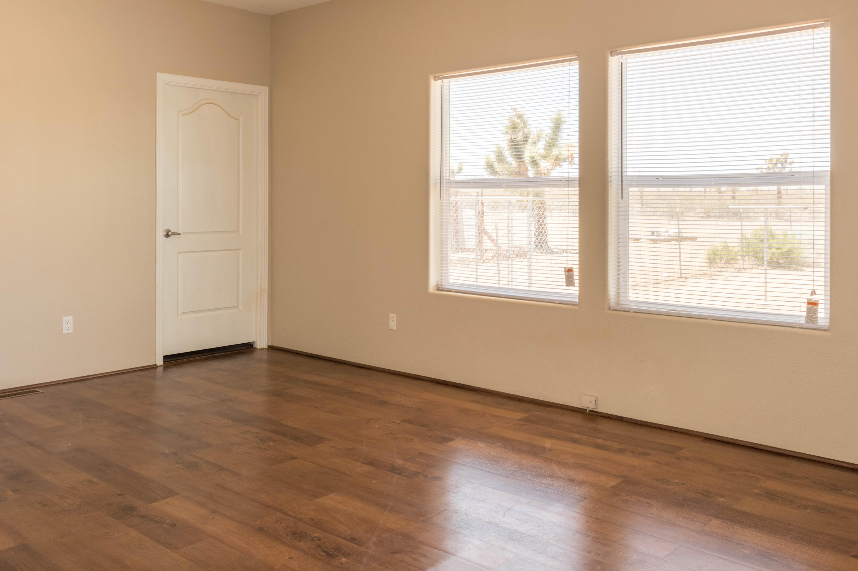 4403 Backus Road Mojave, CA 93501 - Photo 19 of 35 an empty room with wooden floor and windows