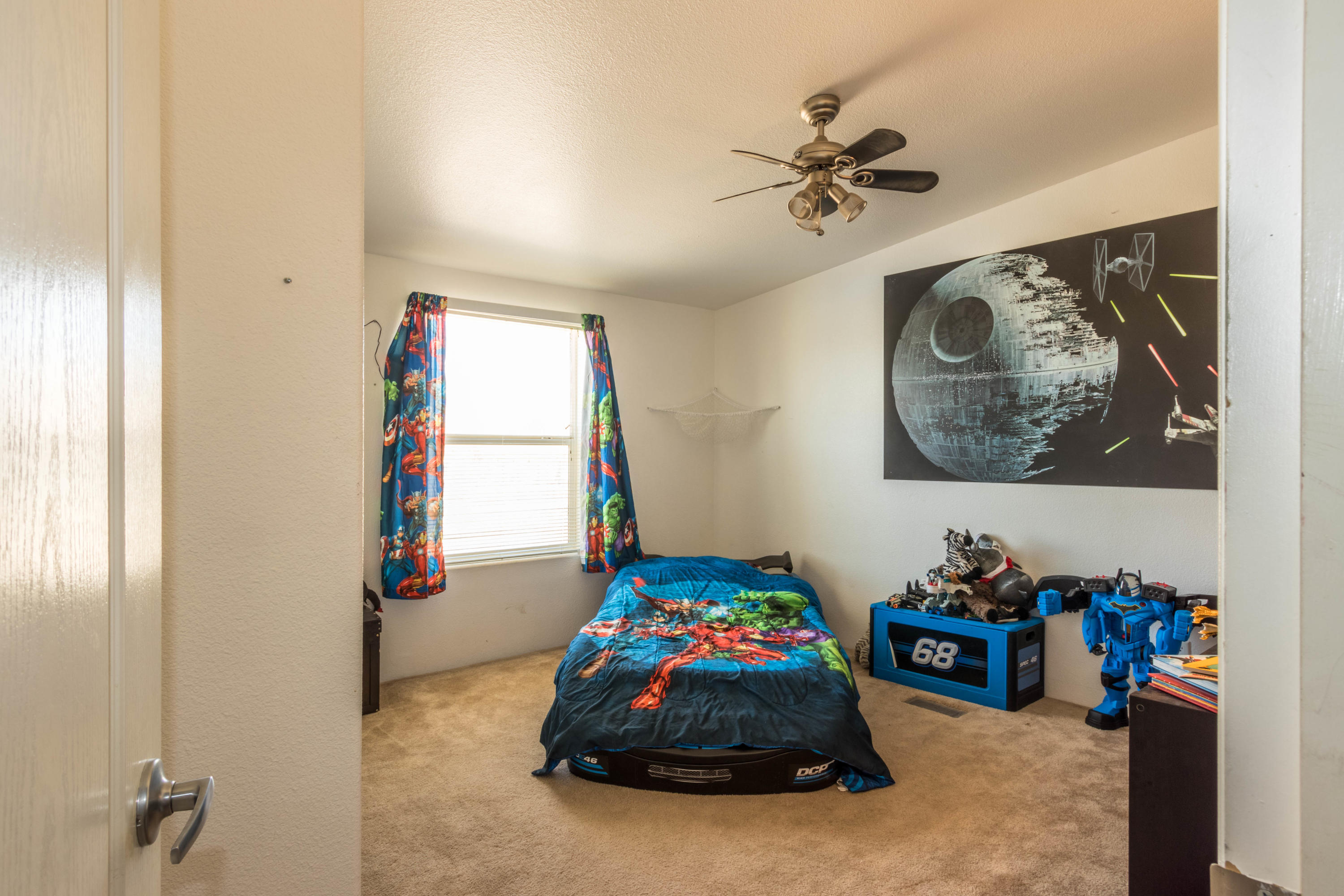4403 Backus Road Mojave, CA 93501 - Photo 22 of 35 a bedroom with a bed and a chandelier
