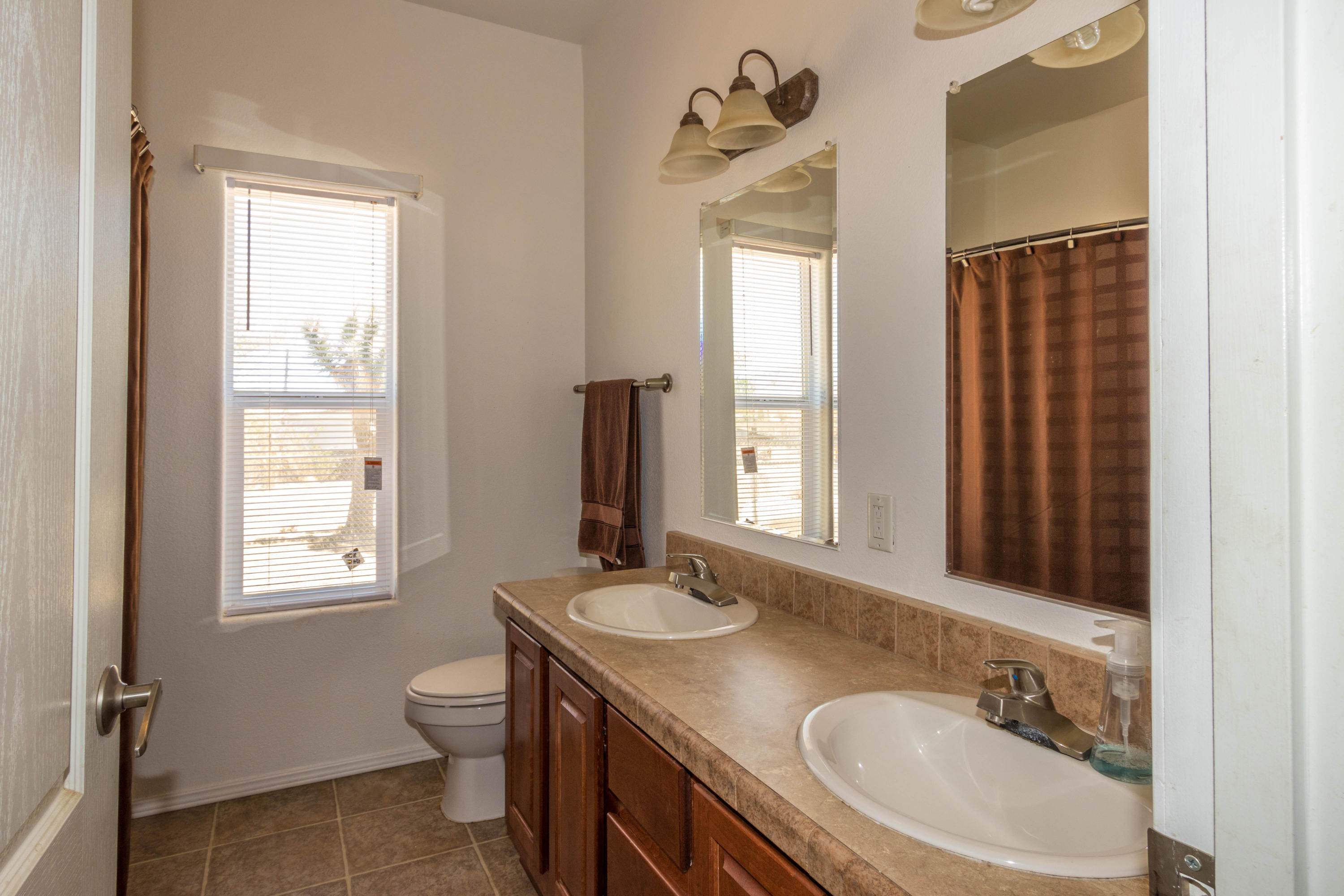 4403 Backus Road Mojave, CA 93501 - Photo 24 of 35 a bathroom with a granite countertop sink toilet a mirror and window