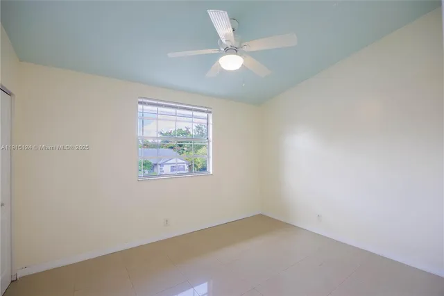 an empty room with a window and a ceiling fan