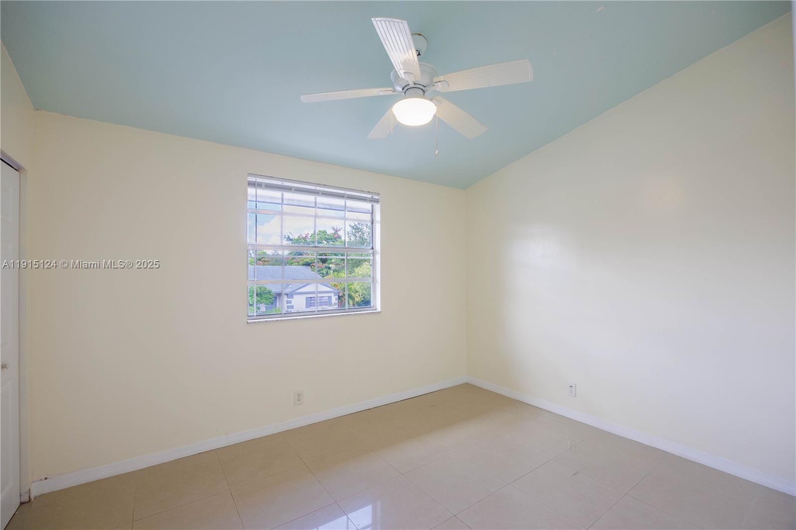 8325 Fairway Road Sunrise, FL 33351 - Photo 14 of 18 an empty room with a window and a ceiling fan