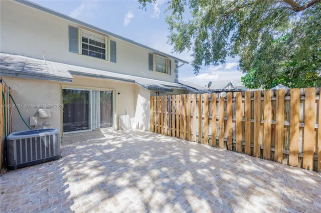 a view of backyard with wooden fence and large trees