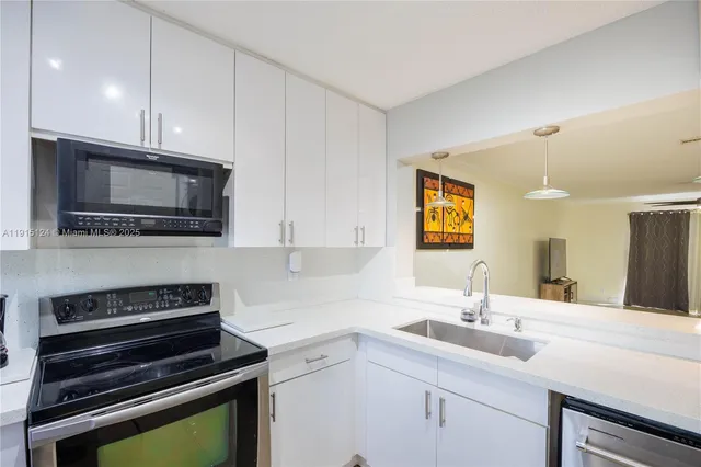a kitchen with a sink and steel appliances