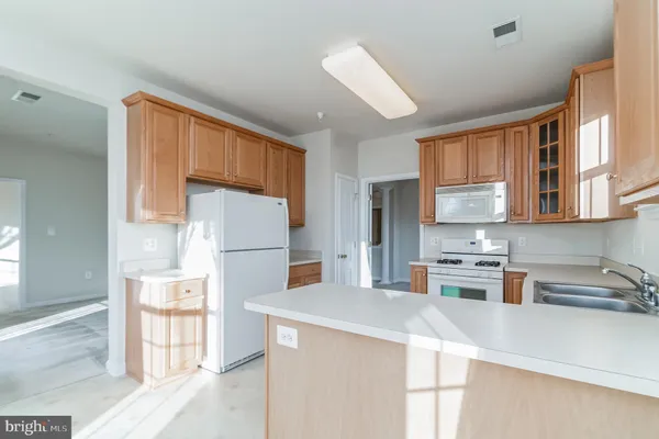 a kitchen with a sink a refrigerator and cabinets