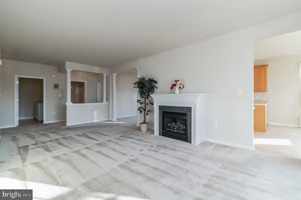 a view of an empty room with window and a fireplace