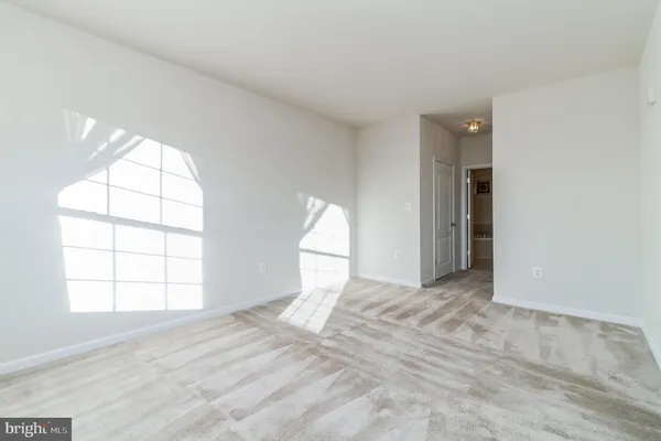 an empty room with windows and cabinet