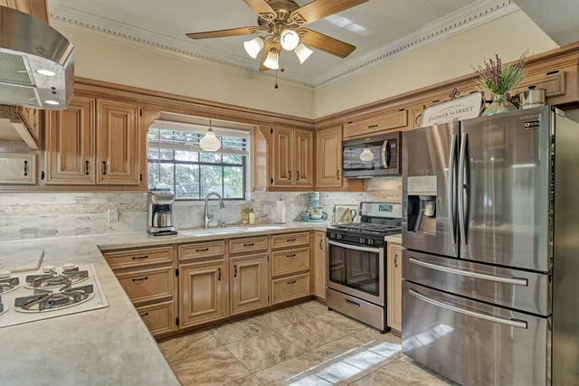 a kitchen with stainless steel appliances granite countertop a sink stove and refrigerator
