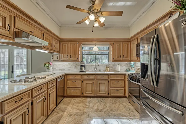 a kitchen with stainless steel appliances granite countertop a sink stove and refrigerator
