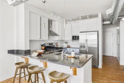 a kitchen with stainless steel appliances granite countertop a sink a stove and a refrigerator