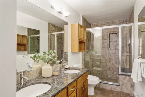 a bathroom with a granite countertop sink toilet and shower