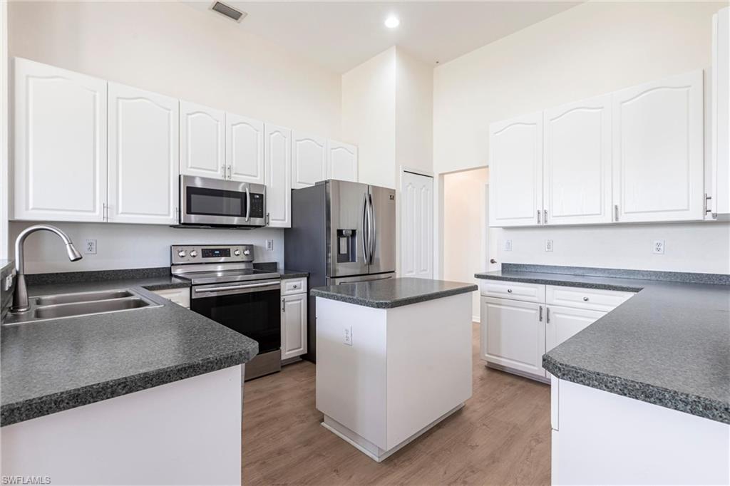 7306 Powder Puff Punta Gorda, FL 33955 - Photo 5 of 34 a kitchen with a sink a stove a microwave and refrigerator