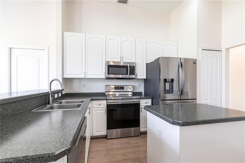7306 Powder Puff Punta Gorda, FL 33955 - Photo 7 of 34 a kitchen with stainless steel appliances granite countertop a sink a stove and a refrigerator