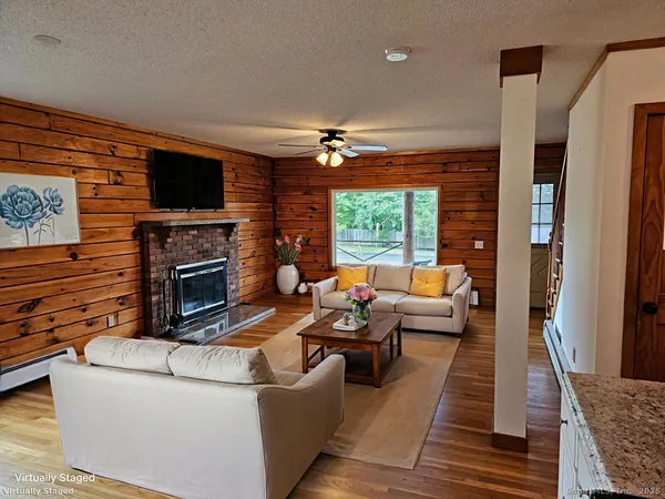 a living room with furniture a flat screen tv and a fireplace