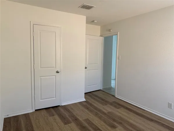 a view of an empty room with wooden floor