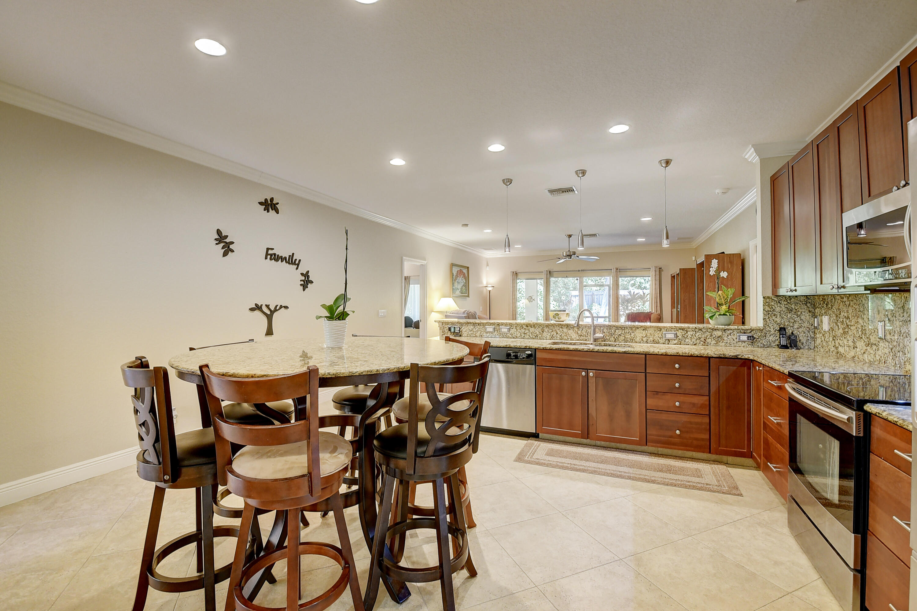 215 Gulfstream Boulevard Boynton Beach, FL 33435 - Photo 15 of 39 a kitchen with stainless steel appliances kitchen island granite countertop a table chairs and white cabinets