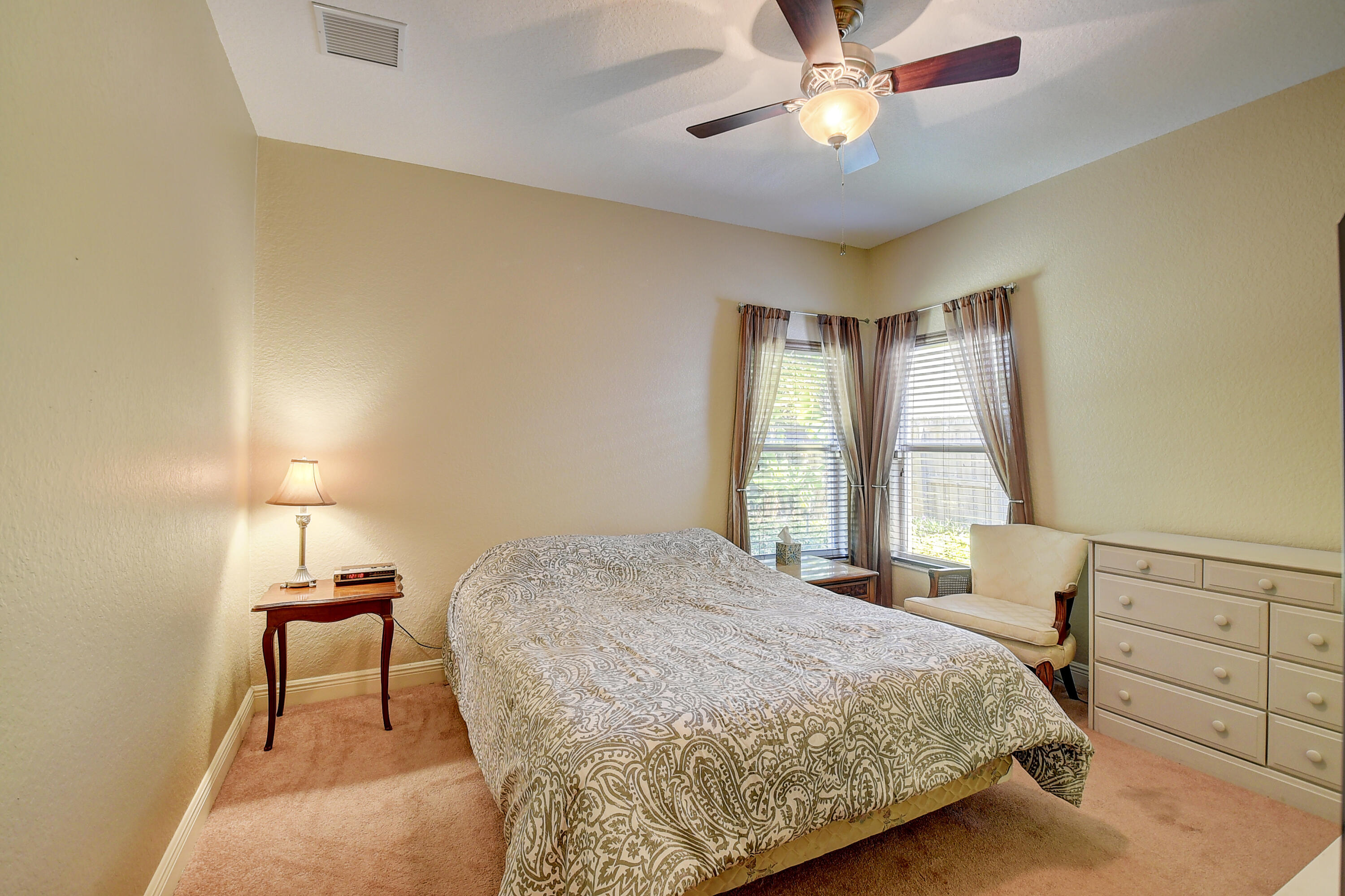 215 Gulfstream Boulevard Boynton Beach, FL 33435 - Photo 27 of 39 a bedroom with a bed and a chandelier