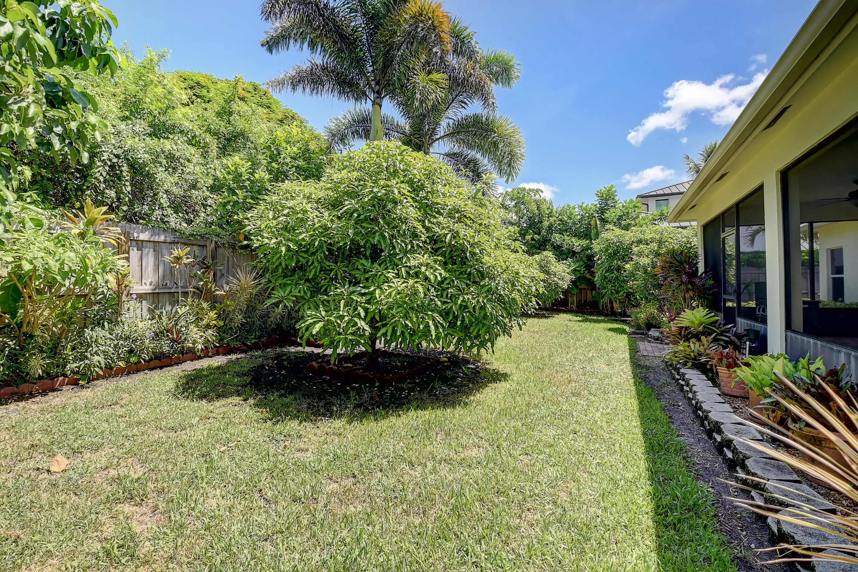 215 Gulfstream Boulevard Boynton Beach, FL 33435 - Photo 31 of 39 a view of a back yard with plants and a bench