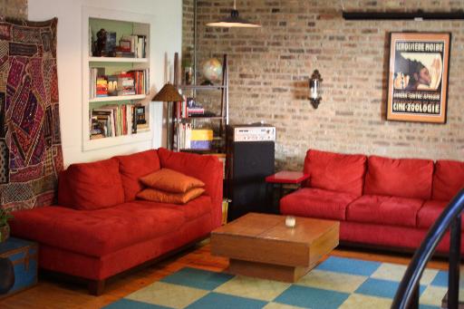 Undisclosed Address Chicago, IL 60642 - Photo 7 of 16 a blue couch sitting in front of a empty room with a rug