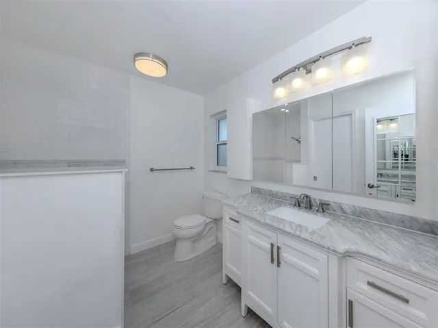 a bathroom with a granite countertop sink and a mirror