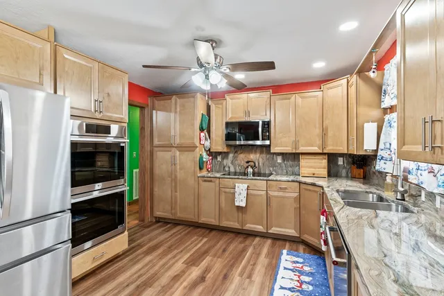 a kitchen with stainless steel appliances granite countertop lots of counter space and a large window