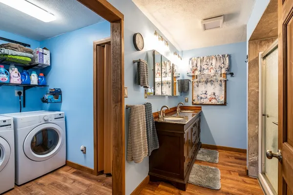 a bathroom with a granite countertop sink and a shower