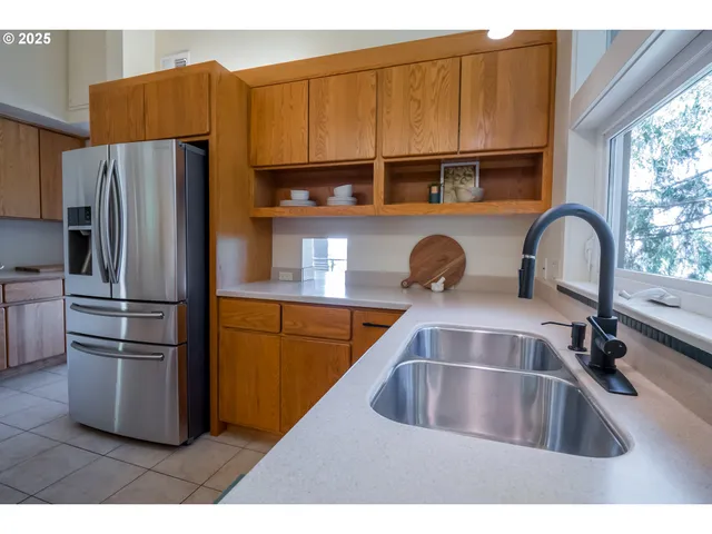 a kitchen with stainless steel appliances a sink a counter top space cabinets and a window