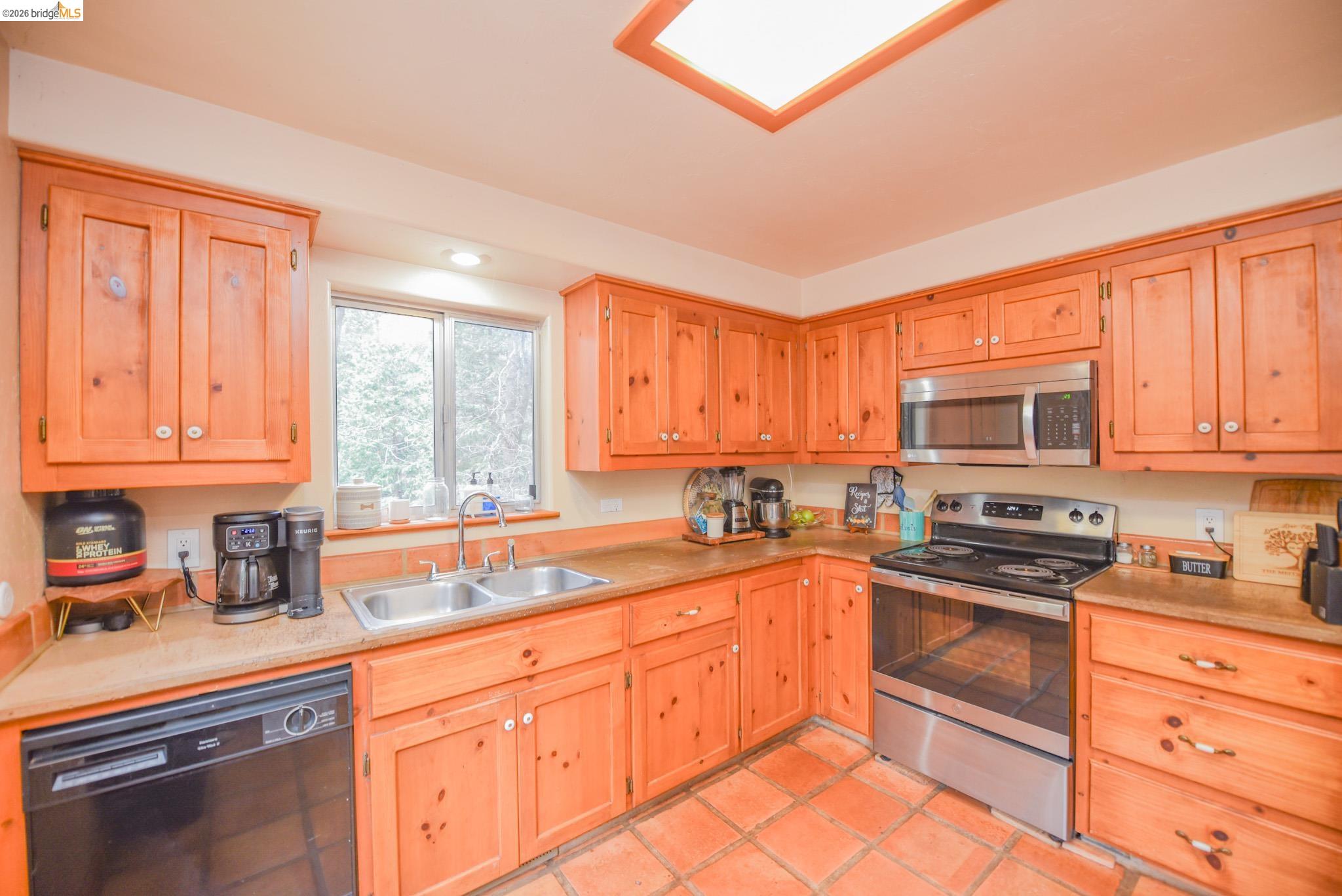 24132 Awahanee Road Sonora, CA 95370 - Photo 10 of 39 a kitchen with granite countertop stainless steel appliances a sink window and cabinets