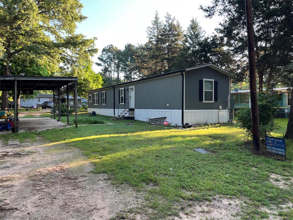 a view of a house with backyard and a tree