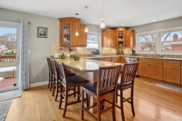 a view of a dining room and livingroom with furniture wooden floor a rug a painting and a chandelier