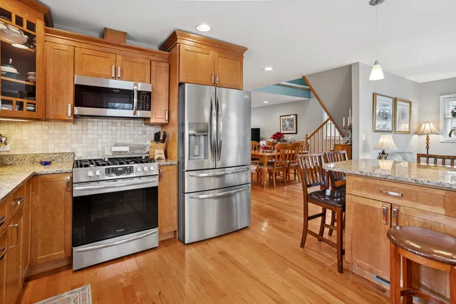 a kitchen with stainless steel appliances a stove a refrigerator and a fireplace