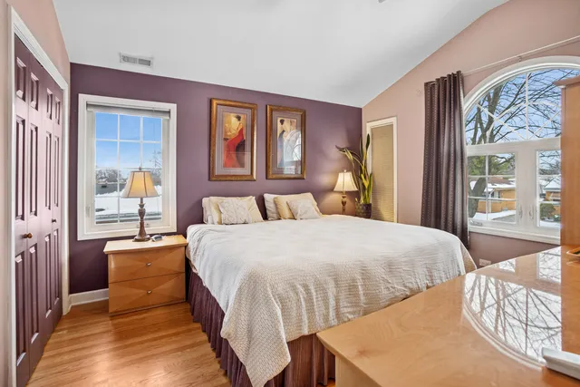 a bedroom with a bed and wooden floor