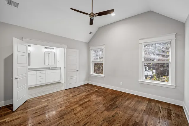 a view of empty room with wooden floor and window