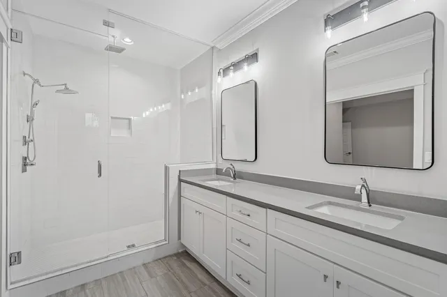 a bathroom with double vanity sinks and a mirror