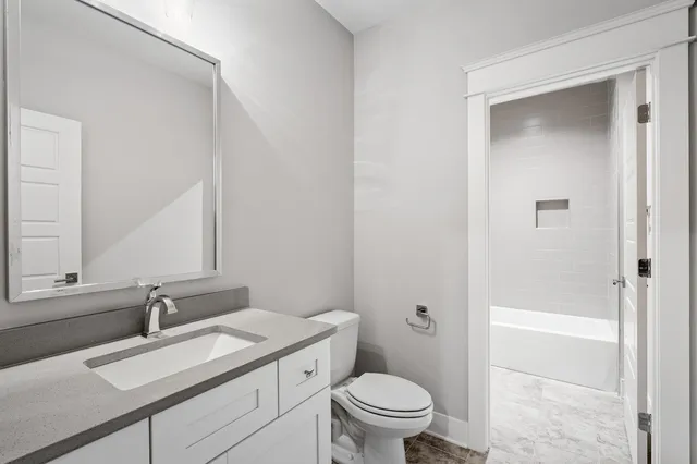 a bathroom with a sink a toilet and a mirror