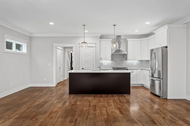a kitchen with granite countertop a refrigerator and a stove top oven