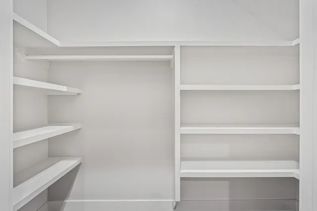 a view of walk in closet with empty racks