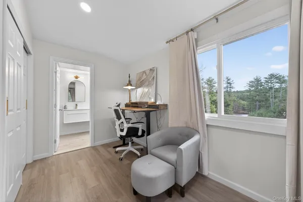 a living room with furniture a bookshelf and a flat screen tv