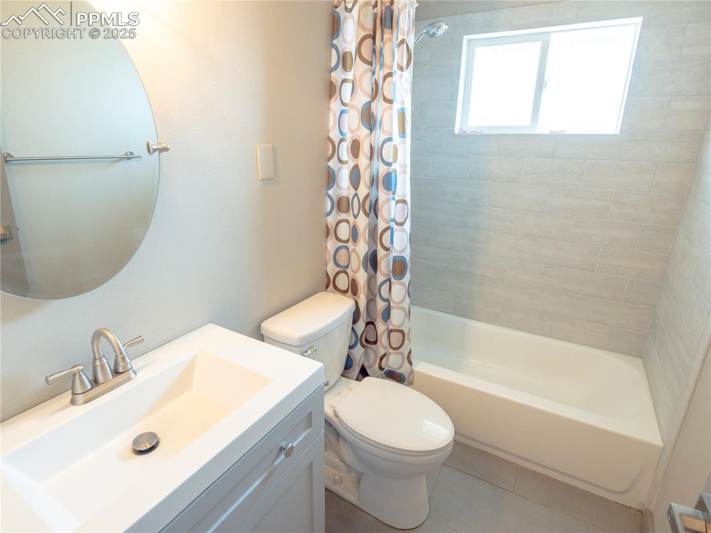 4130 Walker Road Colorado Springs, CO 80908 - Photo 29 of 39 Bathroom featuring vanity, shower / bathtub combination with curtain, and tile patterned floors