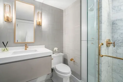 a bathroom with a toilet sink and mirror