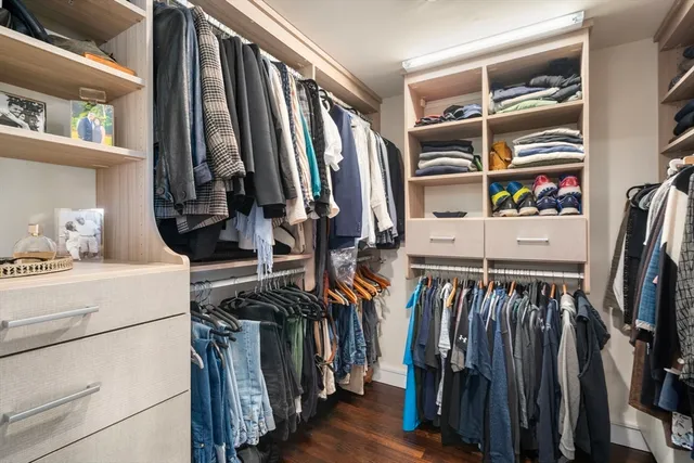 a view of walk in closet with clothes and shoes