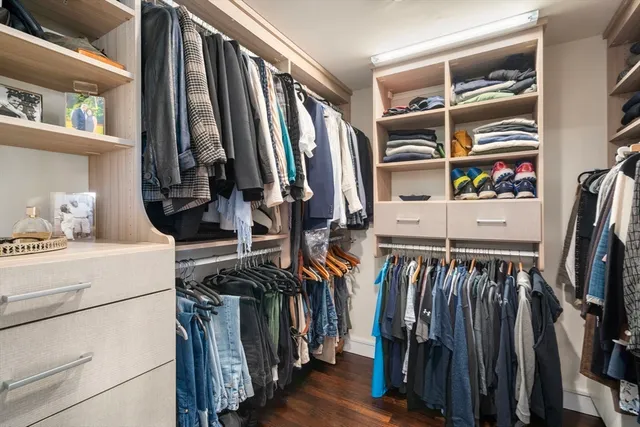 a view of walk in closet with clothes and shoes