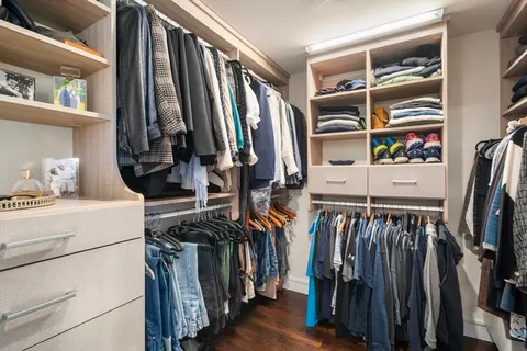 a view of walk in closet with clothes and shoes