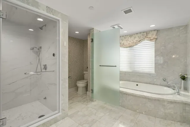 a bathroom with a granite countertop sink a toilet and shower