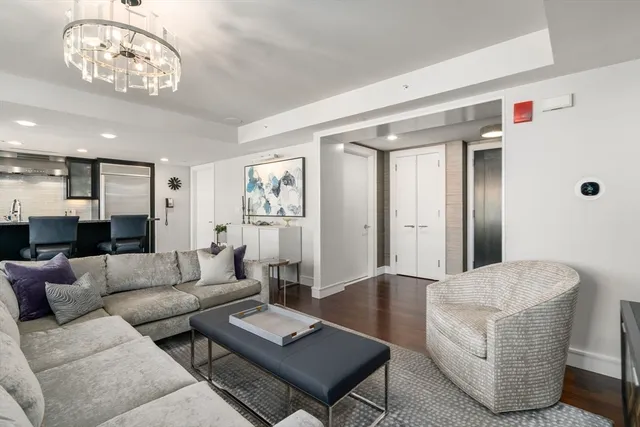 a living room with furniture and a chandelier